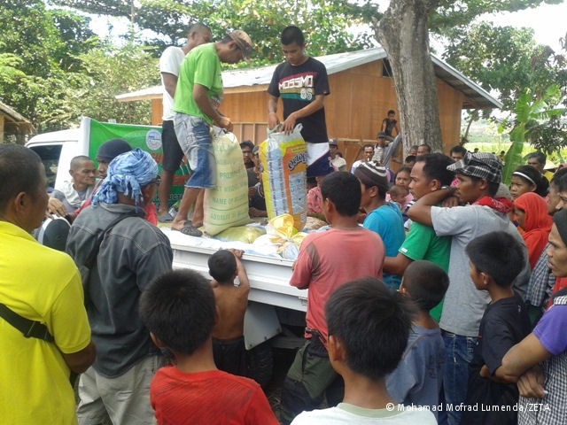 Verteilung von Lebensmitteln in einem provisorisch eingerichteten Lager für intern Vertriebene im Gebiet von Rajah Buayan