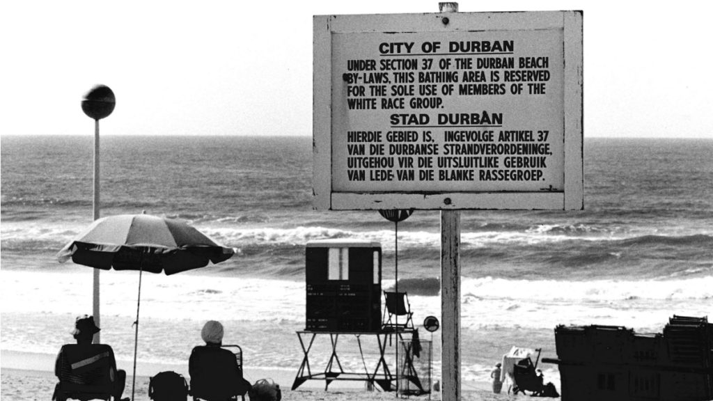 Durban, Südafrika (1982): Ziel und Folge der Apartheid war der gesetzlich gestützte Ausschluss der nicht-weißen Bevölkerungsmehrheit von Lebensraum, politischer Mitbestimmung und Bildung. Dem Schild zu Folge ist dieser Strandabschnitt der damaligen Gesetzeslage entsprechend „für die alleinige Nutzung von Mitgliedern der weißen Rasse reserviert“. © KNA-Bild/MISEREOR
