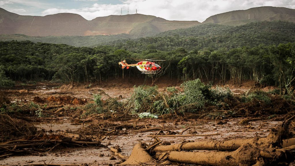 Ein Helikopter über der schlammbegrabenen Landschaft Brumadinhos