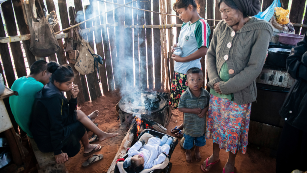 Brasilien: Familie steht um ein Kochfeld in der Hütte und bereitet Essen zu