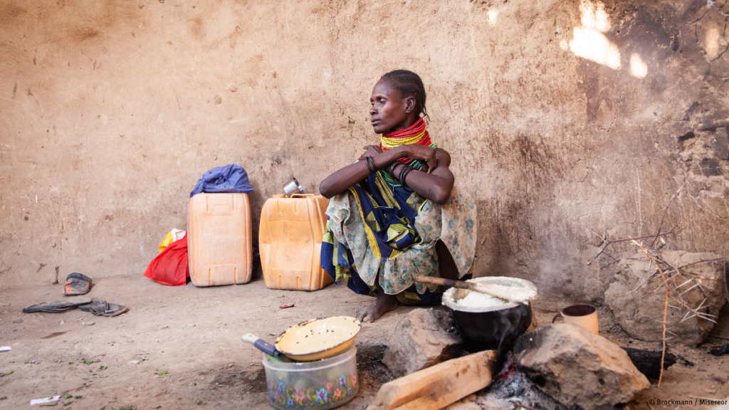 Afrikanische Frau sitzt hungrig auf dem Boden