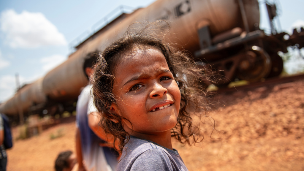 Kinder vor einem Rohstoff-Güterzug