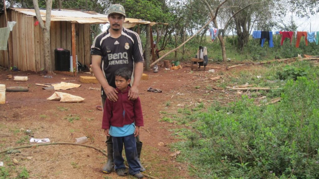 Ein Mann sthet vor einem Kind auf dem Land in Paraguay