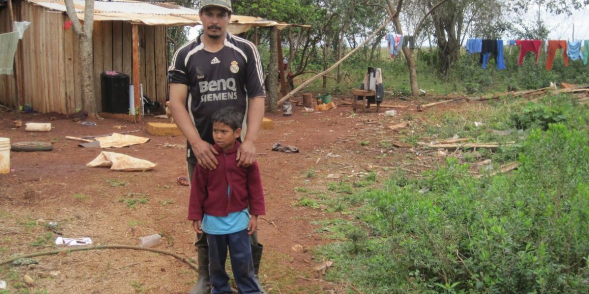 Ein Mann sthet vor einem Kind auf dem Land in Paraguay