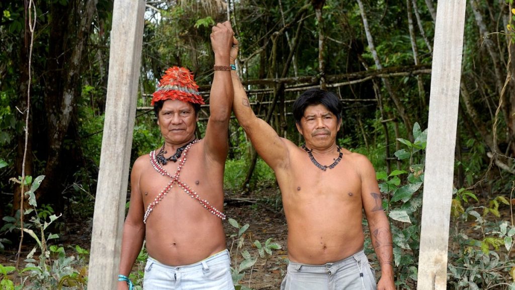 Die Cazique der Mundurukú-Indianer Juarez und Walter an einem Schild, das die Grenze des Gebietes seines Volkes markiert. Dorf der Mundurukú Sawre Jaybu oder "Dorf Juarez" (benannt nach dem Cazique Juarez) am Rio Tapajos, Distrikt Itaituba, Bundesstaat Pará, Brasilien; Foto: Florian Kopp / Misereor